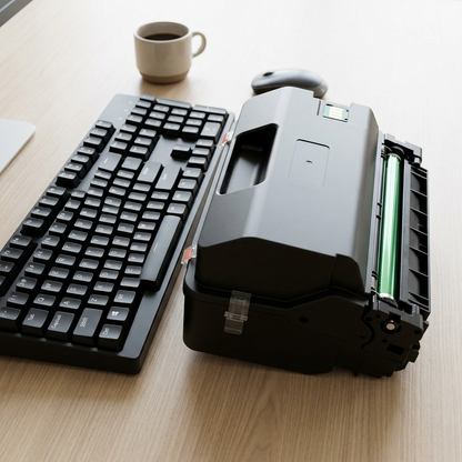 The specific black laser toner cartridge is shown next to a standard keyboard for a clear size comparison.
