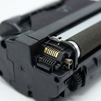 Macro detail of the gold contact pins and developer roller on the Elevate Imaging HP Q5942X toner.