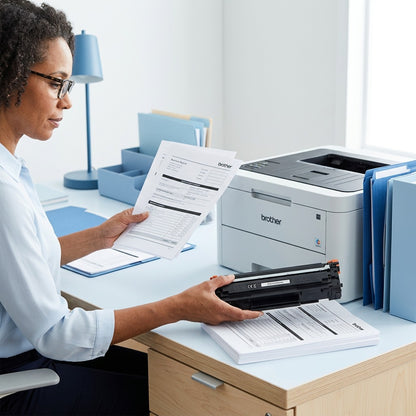 Office professional examining printed documents next to a Brother printer and TN221BK toner cartridge.