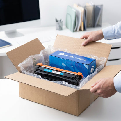 Hands unboxing an Elevate Imaging TN225C Cyan toner cartridge protected by air-cushion packaging.