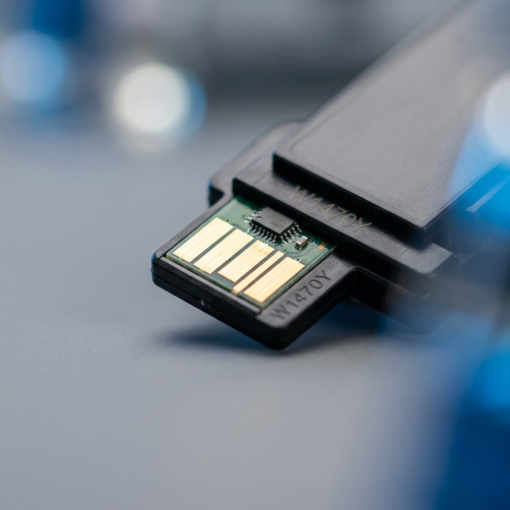 Macro detail of the smart chip with gold contacts on an Elevate Imaging HP W1470Y toner cartridge.