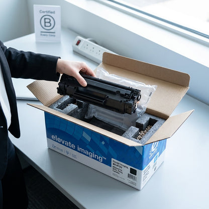 Unboxing of the Elevate Imaging W1470Y toner cartridge from protective foam packaging on a desk.