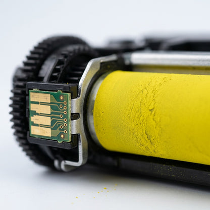 Macro view of the precision contact chip and yellow developer roller on an HP 210X toner cartridge.