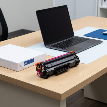 A magenta HP 206A toner cartridge on a desk next to an A4 paper ream and a laptop for scale.