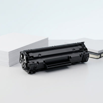 Elevate Imaging compatible HP 12A black toner cartridge on a desk next to a stack of A4 paper.