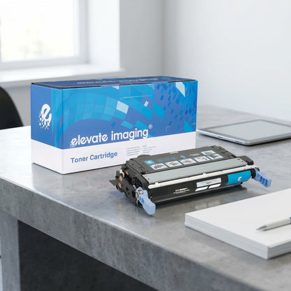Elevate Imaging cyan toner cartridge on a desk with a tablet and paper for scale reference.