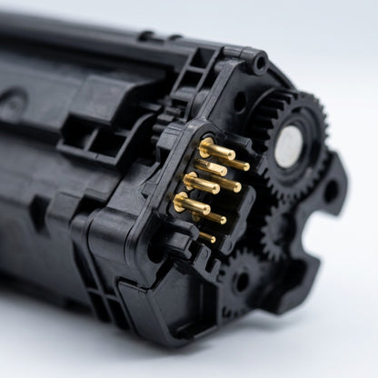Macro detail of the gold contact pins and drive gears on an Elevate Imaging HP CE252A toner cartridge.