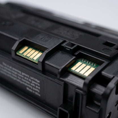 Macro detail of gold-plated electrical contacts and matte black casing on an HP 55X toner cartridge.