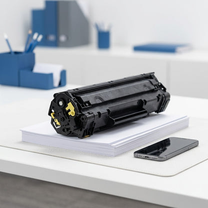 Elevate Imaging CE262A yellow toner cartridge on a stack of A4 paper next to a smartphone for scale.
