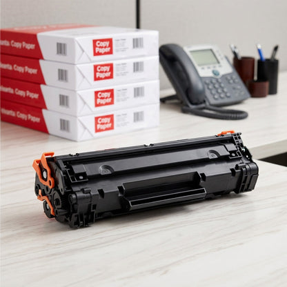 HP 64X (CE264X) high yield black toner cartridge on a desk with paper reams for scale reference.