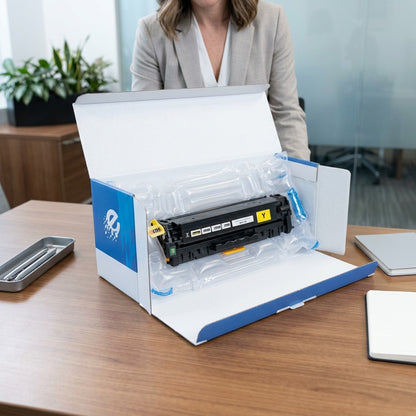 A remanufactured HP 305A yellow toner cartridge being unboxed on a desk, protected by air padding.