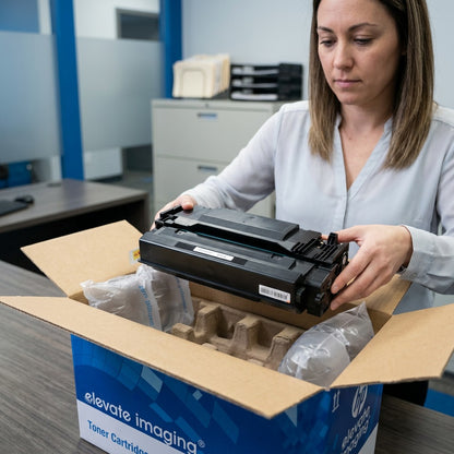 Office manager unboxing an Elevate Imaging HP 87X CF287X toner cartridge from secure packaging.