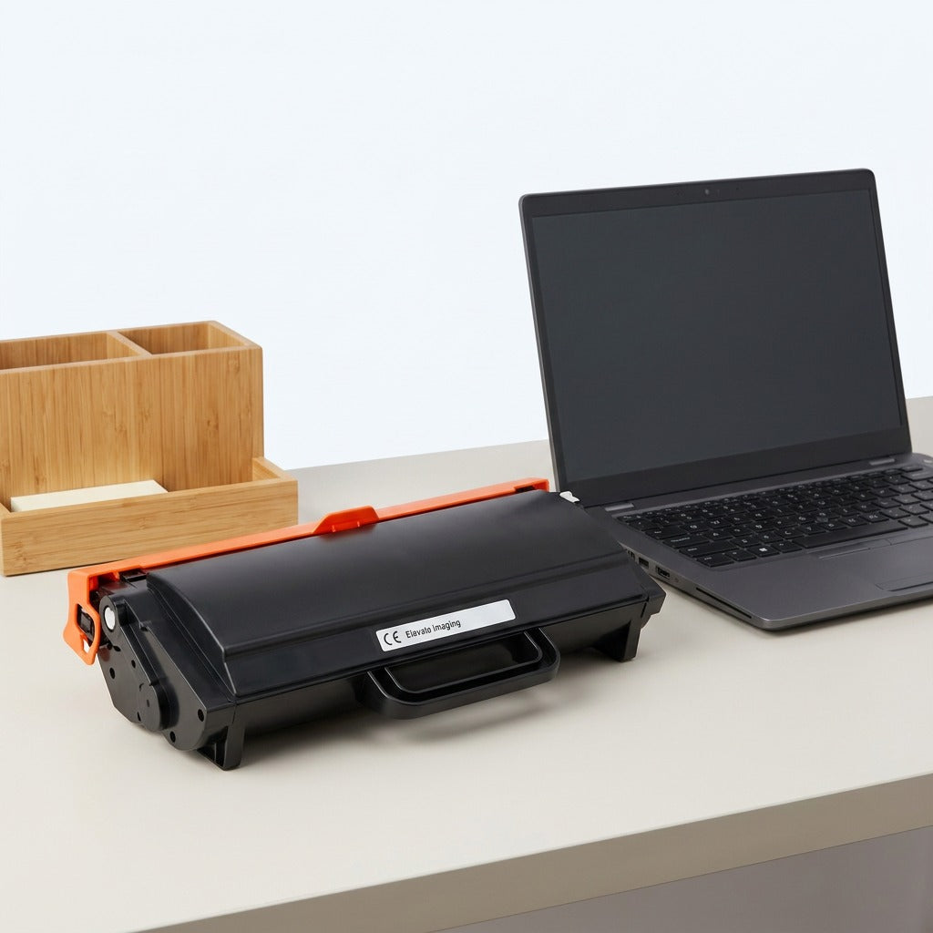 Elevate Imaging HP 89X (CF289X) black toner cartridge on a desk next to a 14-inch laptop for scale.