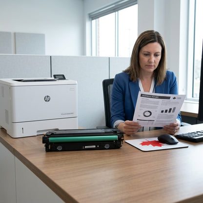 Office professional reviewing a printed report next to an HP printer and an HP 508A black toner.